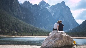 Couple overlooking a lake surrounded by mountains