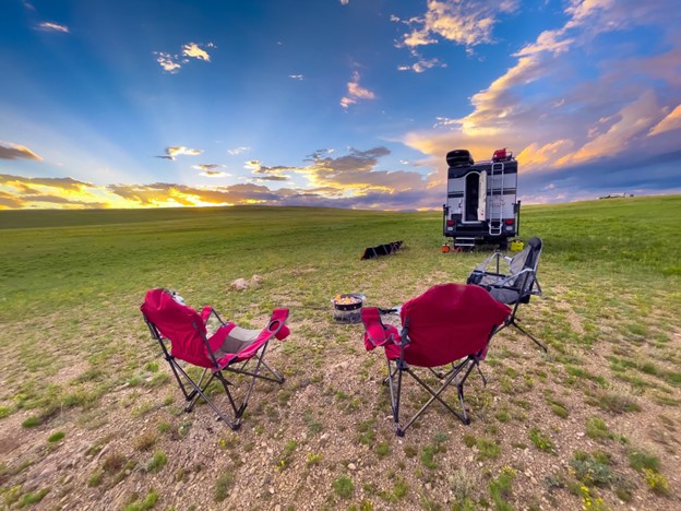 RV motorhome camp in open field at sunset